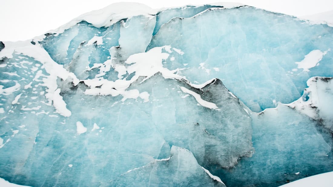 A towering wall of deep-blue glacial ice, evoking the sudden global freeze of the Ordovician.